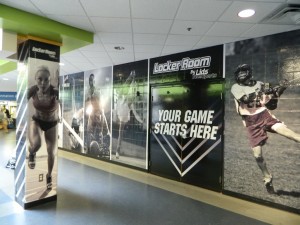 Sports-themed wall mural for LIDS retail store installed by 12-Point SignWorks