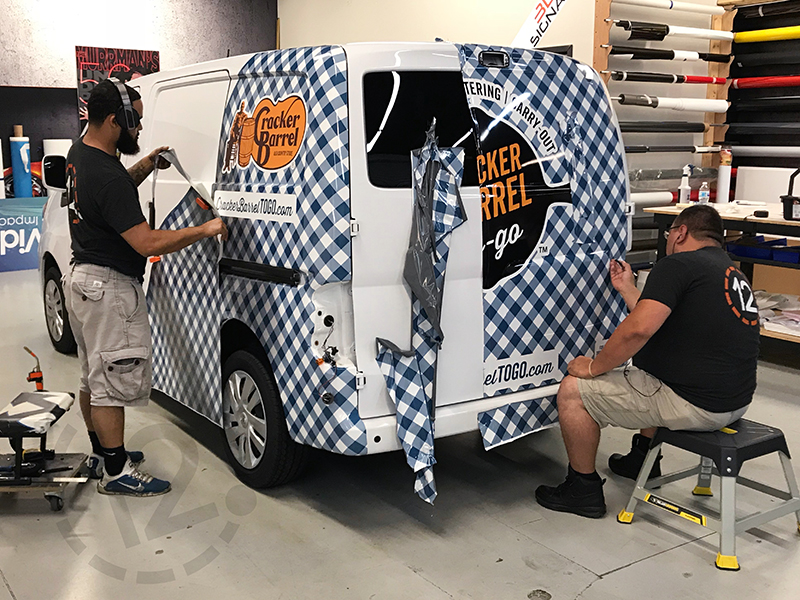 Installation of vehicle wrap for Cracker Barrel Catering by 12-Point SignWorks in Franklin, TN.