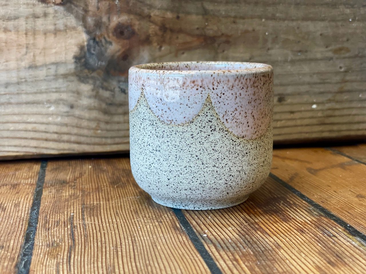 small speckle clay cup with pastel pink glossy scallop glaze