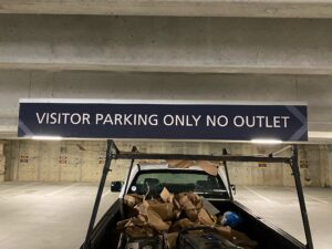 Overhead visitor parking garage sign reading “Visitor Parking Only No Outlet” — property parking garage signage.
