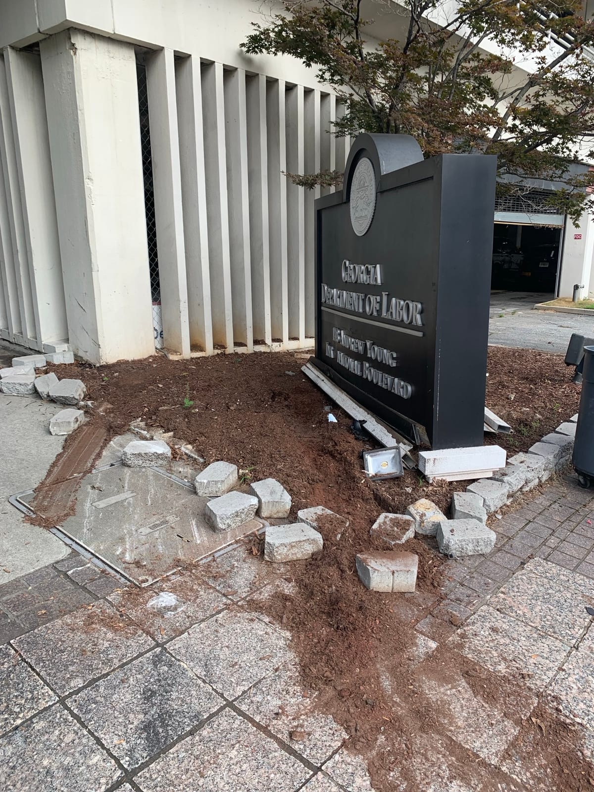 Damaged Georgia Department of Labor monument sign and planter after a second vehicle collision